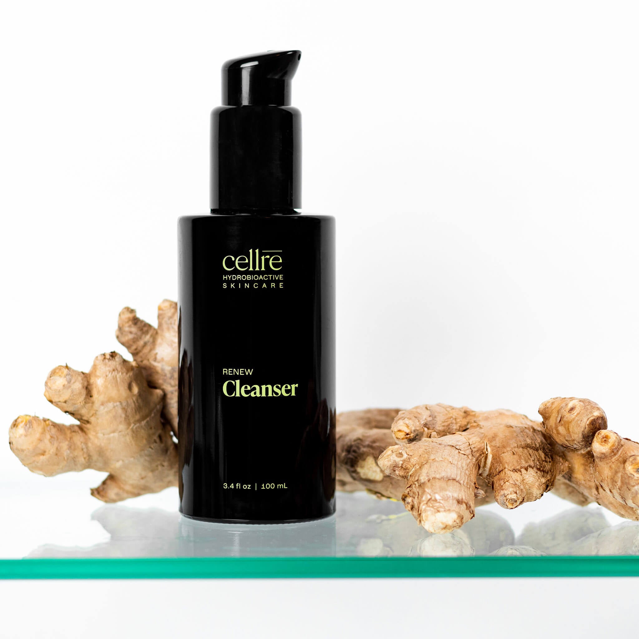 Renew Cleanser with bottle and ginger on a glass shelf